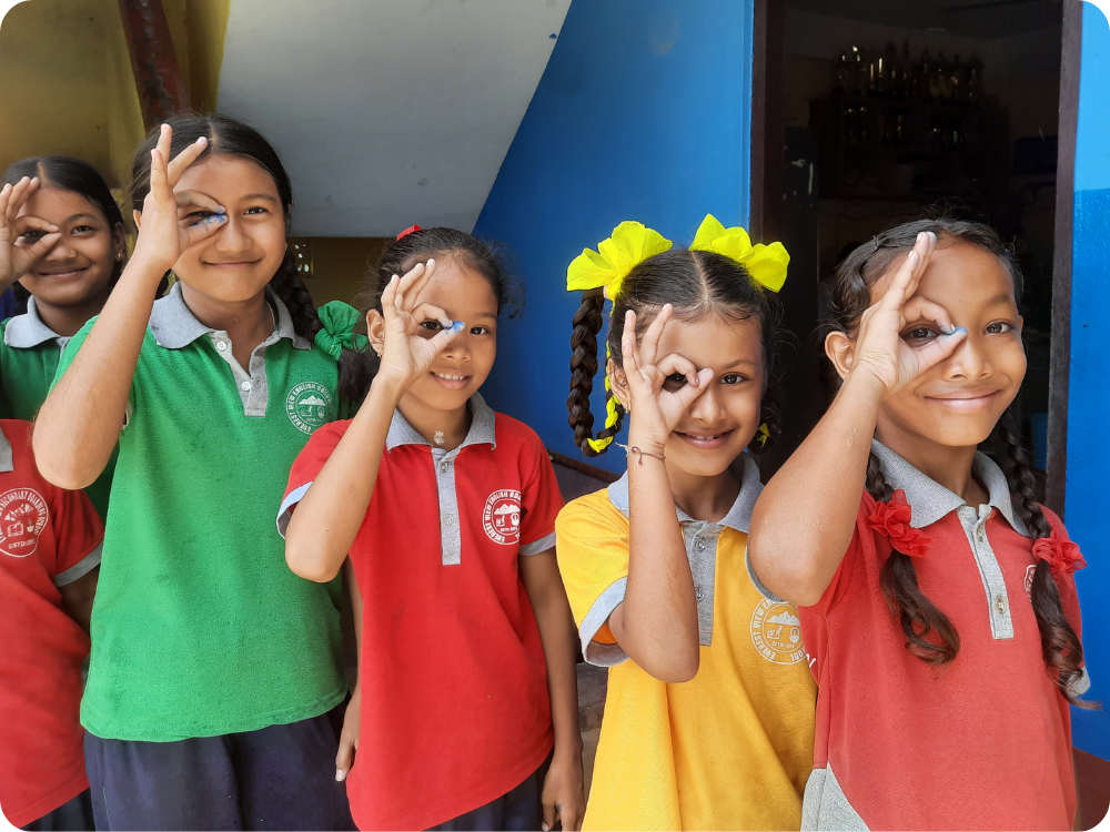 Vier kinderen in Nepal doen oogteken met hun vingers