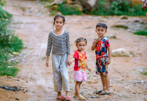 Drie kinderen hand in hand op straat